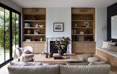 a living room filled with furniture and a fire place in front of a large window