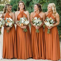 bridesmaids in orange dresses laughing and holding their bouquets at the same time