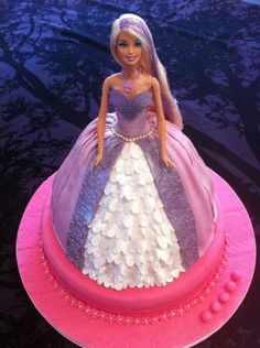 a barbie doll cake on top of a pink plate