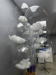 a bunch of balloons that are floating in the air with some clouds on top of them