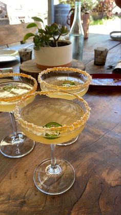 three martinis sitting on top of a wooden table