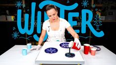 a woman in white shirt and red gloves pouring liquid on plate with blue snowflakes