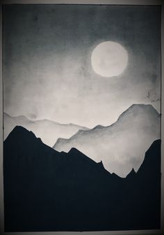 a black and white photo of mountains under a full moon