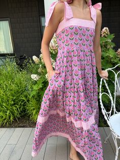 This is it! THE dress of the summer! Meet Maisie, our newest cotton block print maxi dress in a Pink Posey print. She’s full of sweet details like a tiered skirt, and contrasting striped banding. The bow straps are adjustable for the perfect fit, and it features a smocked back panel for comfort. Did we mention it has POCKETS!? Whether you're sipping lemonade on the porch or hitting up a summer wedding or soirée, this dress is a fun, versatile addition to your closet. Throw it on with sneakers or Tiered Cotton Maxi Dress For Garden Party, Cotton Maxi Dress With Tie Straps, Cotton Tiered Skirt Dress For Garden Party, Summer Cotton Dress With Tiered Skirt, Cotton Tiered Skirt Maxi Dress For Garden Party, Cotton Tiered Maxi Dress For Garden Party, Cotton Maxi Dress With Tiered Skirt For Garden Party, Cotton Tiered Sundress For Vacation, Cotton Tiered Dress For Garden Party