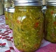 three jars filled with pickles sitting on top of a red and white checkered table cloth