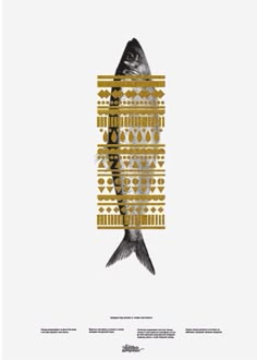 a fish that is sitting on top of a white surface with gold and black designs