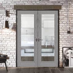 an empty room with brick walls and two doors that have glass panels on each side