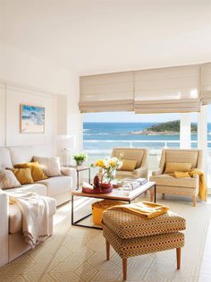 a living room filled with furniture next to the ocean