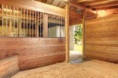 the inside of a horse barn with wooden walls