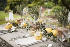 the table is set with wine glasses and lemons