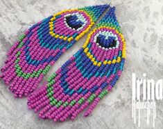 a pair of colorful beaded earrings on top of a stone surface with the words prima shop written below it