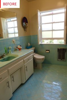 a bathroom with blue tile and white cabinets