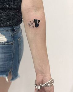 a woman's arm with a cat tattoo on the left side of her arm