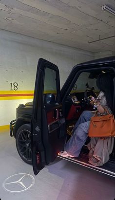 a woman sitting in the back of a black truck