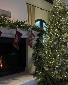 a decorated christmas tree in front of a fireplace