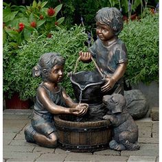 two children playing with a water fountain statue