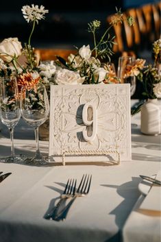 the table is set with silverware and flowers