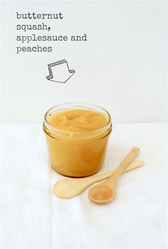 a jar of peanut butter and two wooden spoons on a white tablecloth with the words butternut squash, applesauce and peaches