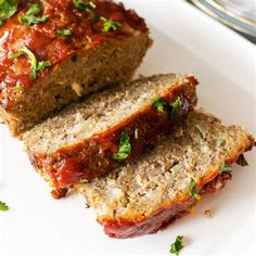 two slices of meatloaf sitting on top of a white plate with parsley