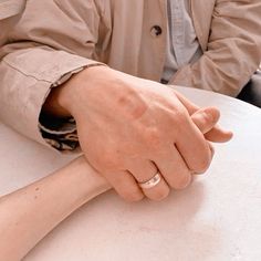 two people sitting at a table with their hands on each other's wrists