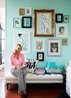 a woman sitting on top of a couch in front of pictures