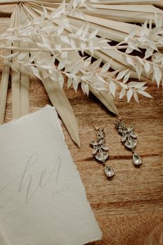 the bride's earrings are on display next to their bouquet