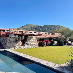 a house with a pool in front of it and mountains in the backround