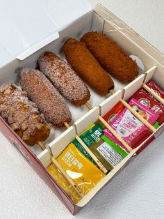 a box filled with different types of doughnuts and other foods on sticks next to each other