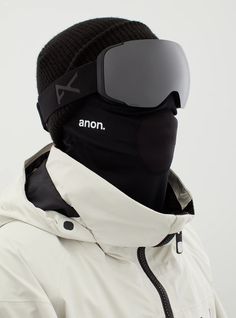 a person wearing a white jacket and black hat with ski goggles on their head