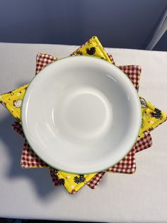 a white bowl sitting on top of a table next to napkins and a fork