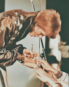 a man is getting his nails done by two women