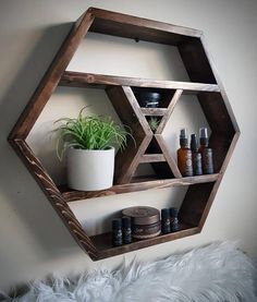 a wooden shelf with some bottles on top of it and a potted plant in the corner