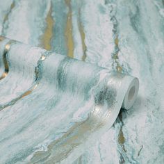 a roll of metallic foil sitting on top of a marble tablecloth covered in gold and silver