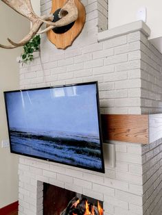 a flat screen tv sitting on top of a fireplace