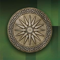 a circular object with an intricate design on the front and side of it, against a green background