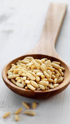 a wooden spoon filled with sunflower seeds on top of a table