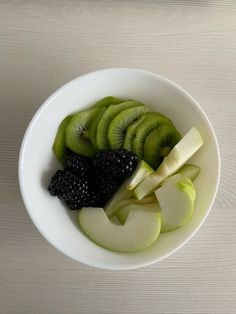 a white bowl filled with sliced fruit on top of a table