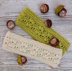 two crocheted headbands sitting next to acorns