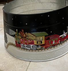 a train painted on the side of a metal container sitting on top of a tile floor