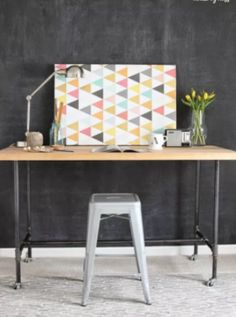 a desk with a blackboard behind it that says diy piping + butcher block table