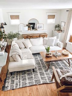 a living room filled with white furniture and lots of pillows on top of it's couches