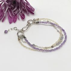 Layered gemstone bracelet is sure to become a favorite. Not only do gray sapphire and citrine gemstones adorn this classic bracelet set…but amethyst gemstones do as well. First, petite sapphire gemstones, which are softly hued, sit between sections of dapped Argentum silver chain. Second, luscious citrine gemstones make up another strand. Third, you’ll find delicate amethyst stones making the last layer. These beauties are also softly hued and translucent. Elegant Gemstone Beaded Bracelets For Friendship, Dainty Faceted Everyday Bracelets, Dainty Faceted Bracelet For Everyday, Delicate Silver Gemstone Bracelets, Dainty Everyday Faceted Bracelets, Dainty Faceted Everyday Bracelet, Elegant Everyday Faceted Beaded Bracelets, Adjustable Sterling Silver Crystal Bracelet, Silver Double Strand Bracelet With Natural Stones