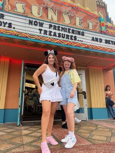 two girls standing in front of a theater