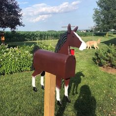 a mailbox shaped like a horse standing in the grass