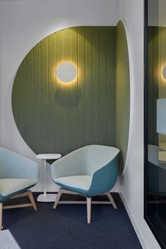 two chairs sitting next to each other in front of a wall with circular lights on it