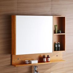 a bathroom mirror mounted to the side of a wooden wall