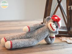 a crocheted sock monkey with a red flower on it's head and legs