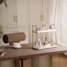 a table with various items on it in a living room next to a white wall