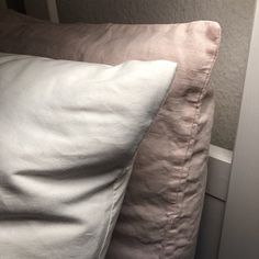 two pillows sitting next to each other on top of a bed