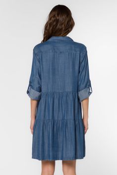 Our best selling tiered babydoll dress made in a lightweight denim-blue chambray Tencel™. It features a basic collar, button-up front, roll-tab sleeves, back yoke, front flap pockets, and a knee-length hem. Material: 100% Tencel™ Eco-Friendly Machine wash Color: 754 Calva Model is 5'9" and wearing a size S Imported Tiered Babydoll Dress, Velvet Heart, Babydoll Dress, Denim Blue, Designer Collection, Blue Dress, Chambray, Dress Making, Jumpsuit Dress